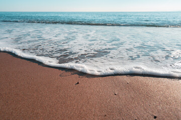 Smooth sandy at the beach and beautiful wave in background. Soft wave blue ocen and sandy beach. Small waves lapped the beach