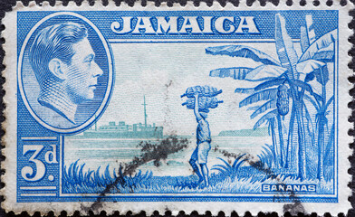 Obraz premium Jamaica - circa 1949: a postage stamp from Jamaica, showing a banana plantation harvesting with a ship on the ocean and a portrait of King George V
