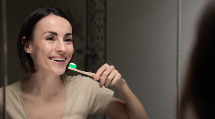 Close up portrait of a beautiful healthy woman while she cleaning her teeth with help of a...