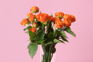 Bouquet of beautiful orange roses on pink background