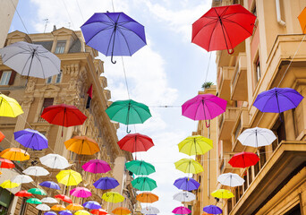 Colorful umbrellas background with blue sky in the city street decoration, Hanging Colorful umbrella in street decoration, Street decorated with colored umbrellas, Genova italy.