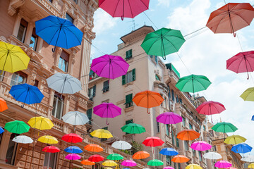 Colorful umbrellas background with blue sky in the city street decoration, Hanging Colorful umbrella in street decoration, Street decorated with colored umbrellas, Genova italy.