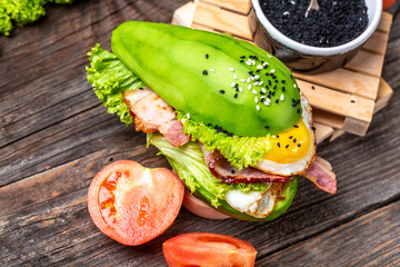 Avocado bun burger with bacon, egg, tomato, Low carb high fat breakfast, Delicious breakfast or snack, keto paleo diet