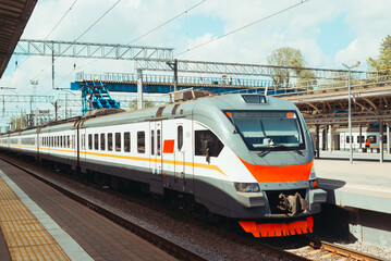 Fototapeta na wymiar Modern high-speed electric train standing at railway station on summer sunny day, outdoors