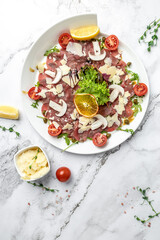 Fototapeta na wymiar Beef carpaccio with parmesan capers and arugula. cold appetizer. italian cuisine. vertical image. top view. place for text
