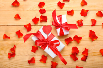 Gifts for Valentine's Day and rose petals on wooden background