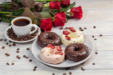 Handmade donuts on a light background in white and black chocolate. There are flowers nearby. Women's day, Valentine's day.