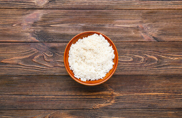 Fototapeta na wymiar Bowl with tasty boiled rice on wooden background