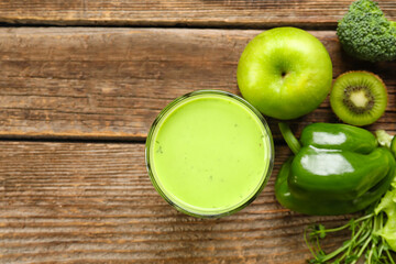 Glass of healthy green juice and fresh ingredients on wooden background