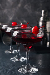 Glasses of tasty Manhattan cocktail on black background