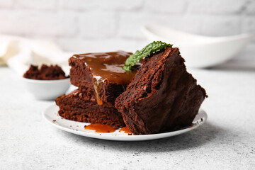 Plate with pieces of tasty chocolate brownie on table