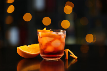 Glass of tasty Negroni cocktail on table against blurred background