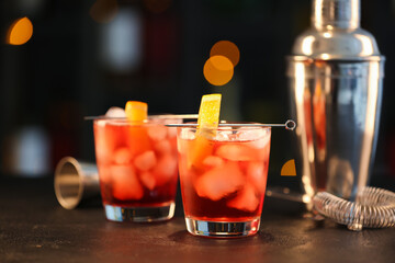 Glasses of tasty Negroni cocktail on table against blurred background