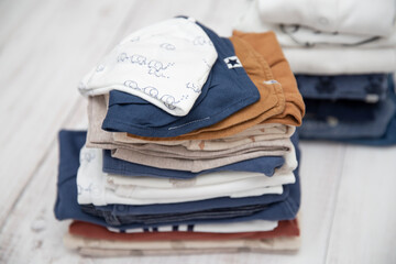 Folded baby clothes white white bloe and brown colors