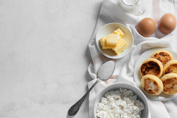 Plate with tasty cottage cheese pancakes and ingredients on white background