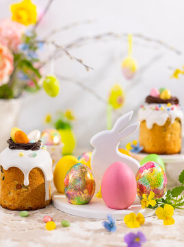 Easter still life with colorful Easter cakes, Easter eggs on rabbit dessert plate. Traditional Easter treat
