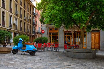 Obraz premium Old street with table of restaurant in Madrid, Spain. Architecture and landmark of Madrid, postcard of Madrid.