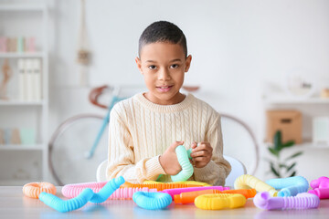 Little African-American boy playing with Pop Tubes at home