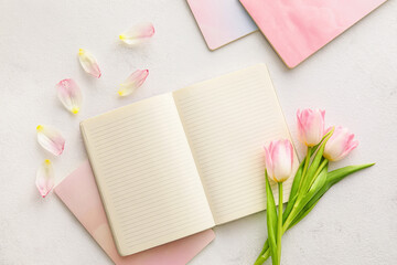 Composition with notebooks and beautiful tulips on light background