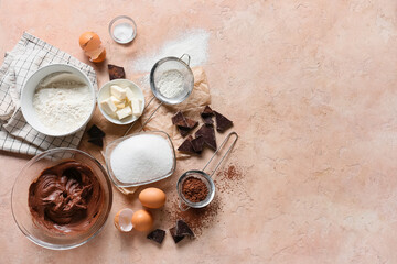 Fototapeta na wymiar Bowl with fresh dough and ingredients for preparing chocolate brownie on beige background