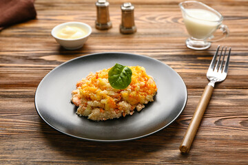 Plate with tasty English fish pie on wooden background