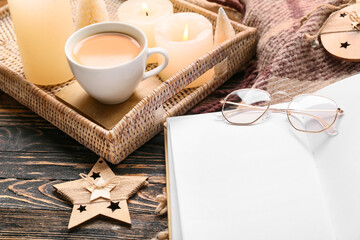 Fototapeta na wymiar Opened book with blank pages, eyeglasses and tray with cup of coffee on wooden background, closeup