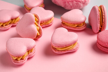 Tasty heart-shaped macaroons on color background, closeup