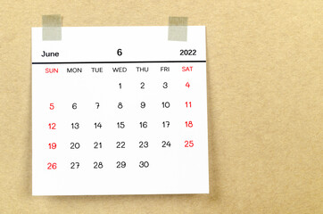 June 2022 calendar on brown background.