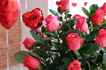 Beautiful roses in room decorated for Valentine's Day, closeup