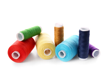 Different sewing thread spools on white background