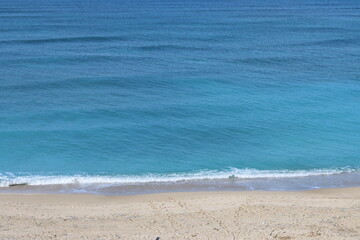 Fototapeta na wymiar Tranquil scenery. Blue sea water, sand, no people. Beautiful day on a beach.