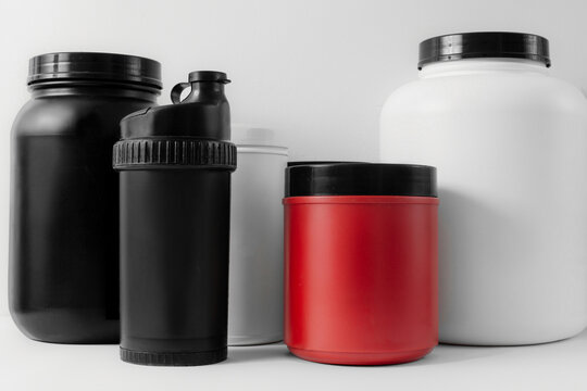 containers of weight gainers, protein and creatine on a white isolated background