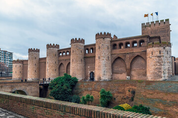 Fototapeta premium Saragossa, Spain - November 29, 2021: Exterior of the medieval stone fortress Aljaferia Palace in Zaragoza. Cityscape with ancient tourist attraction of spanish city