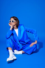 Fashion asian female model in blue suit, white boots and sunglasses. - 482010952
