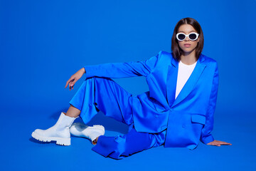 Fashion asian female model in blue suit, white boots and sunglasses. - 482010965