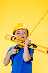The preschooler in a helmet with a construction level plays a builder