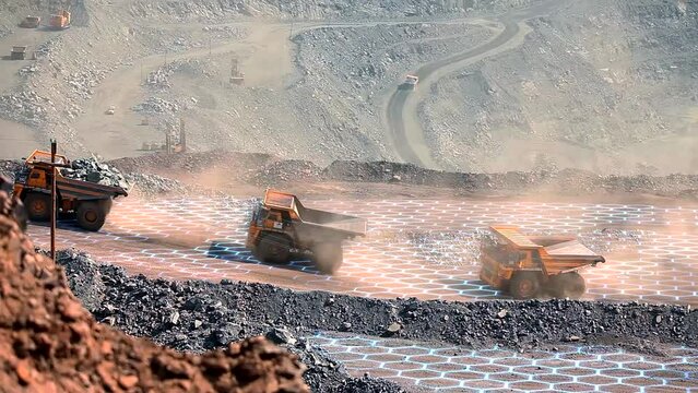 Three mining dump trucks ride through an iron ore quarry. Iron ore mining process. Visualization of modern technologies in the iron ore industry