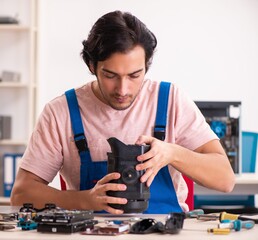 The young male contractor repairing computer