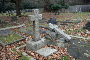 Old Graveyard with Broken and Fallen Crosses and Graves in Overgrown Grass Spooky