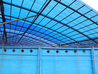 Obraz premium Translucent spherical canopy made of bright blue polycarbonate. The structure above the open business area (warehouse) is mounted on metal supports.