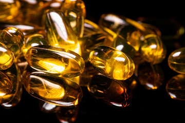 Close up of Omega 3 gel capsule on a reflective black background