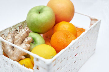 fruit basket on white background, apples oranges lemons ginger