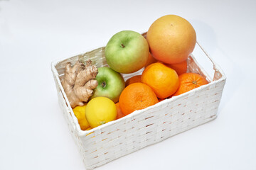 fruit basket on white background, apples oranges lemons ginger