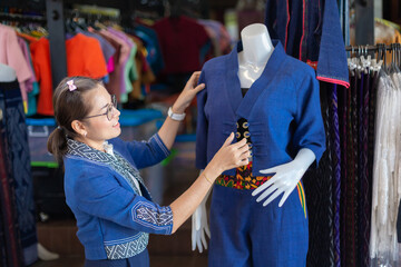 Asian women buy traditional clothing made by hand weaving and dyed indigo.
