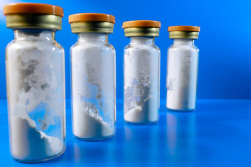 Vials of medicines with red caps. Closed medicine bottles. Vials with white powder. Medicines for injection