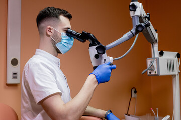 A young scientist conducting research with a microscope. Working with a microscope