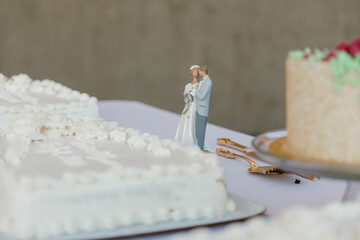 Romantic bride and groom dancing cake topper near the white wedding cake Close-up of figurine...