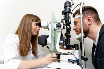 Fototapeta premium Ophtalmology specilaist examining patient eyes. Professional vision diagnostic by young medical specialist.