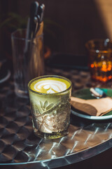 Plant based milk with coffee in a glass cup. Vegan restaurant. Sunny weather.