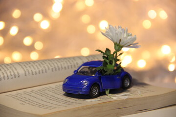 a little blue car autobus with white flower